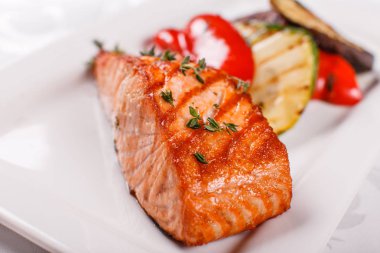 Kırmızı sıcak ve baharatlı fileto balık. Izgara biftek somon veya alabalık ızgara kırmızı biber ve kabak ile. Sağlıklı gıda, deniz ürünleri ve sebze.