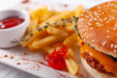 Fast food restoran menü. Ev yapımı hamburger sığır köftesi, soğan, domates, marul ve peynir ile. Taze hamburger yakın çekim. Altın patates kızartması patates ile süslenmiş