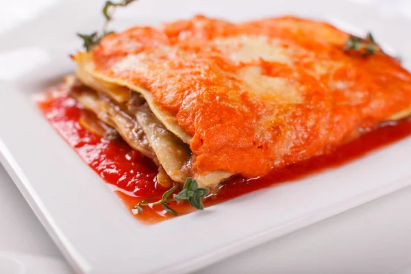 Итальянская еда. Классическая лазанья с колбасным соусом на белой тарелке . — стоковое фото