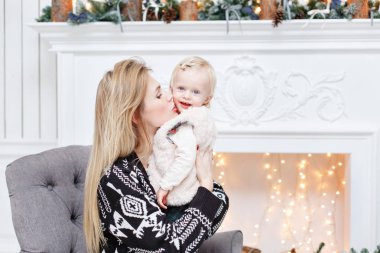 Neşeli anne şirin bebek kızını kucaklıyor. Anne-baba ve küçük çocuk kapalı Noel ağacı yakınındaki eğleniyor. Sevgi dolu aile mutlu Noeller ve mutlu yeni yıl