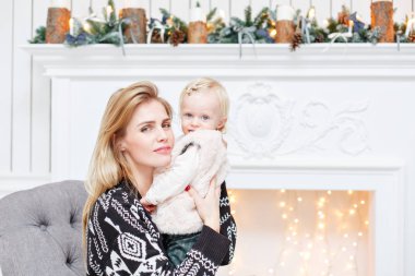 Neşeli anne şirin bebek kızını kucaklıyor. Anne-baba ve küçük çocuk kapalı Noel ağacı yakınındaki eğleniyor. Sevgi dolu aile mutlu Noeller ve mutlu yeni yıl