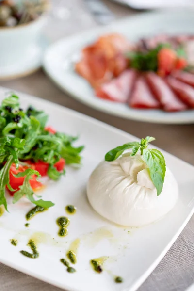 Salade italienne Caprese. fromage burrata, tomates et feuilles de basilic. Vinaigre balsamique disposé sur une assiette blanche — Photo