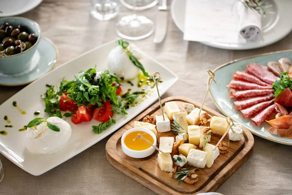 Ensalada Caprese italiana y plato de queso.. queso burrata, tomates y hojas de hierba de albahaca. Vinagre balsámico dispuesto en plato blanco —  Fotos de Stock