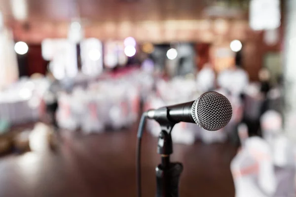 Microphone over the Abstract blurred photo of banquet room or seminar room with people background,party or meeting concept.