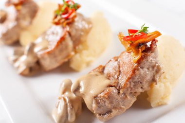Patates püresi ve mantar ile domuz eti madalyon. Domuz eti bonfile iyi hizmet veren bir beyaz tabakta. Restoran menü