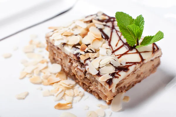 Almond cake. Piece of Cake with leaf mint on a Plate. Sweet food. Sweet dessert. Food background. Close up. — Stock Photo, Image