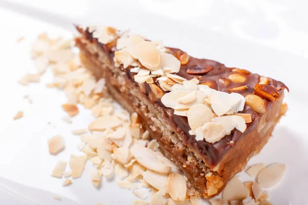Nuts cake. Piece of Cake with almond ant peanut on a Plate. Sweet food. Sweet dessert. Food background. Close up.
