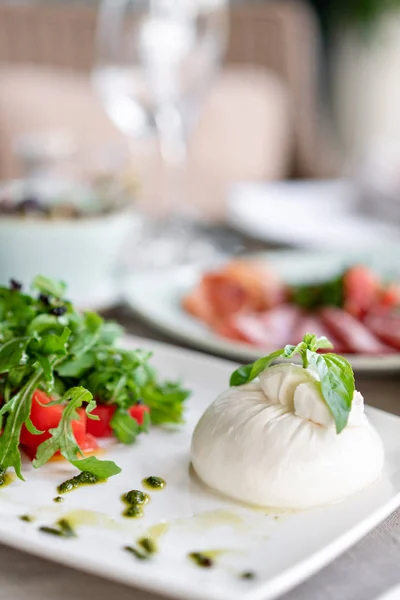 Salade italienne Caprese. fromage burrata, tomates et feuilles de basilic. Vinaigre balsamique disposé sur une assiette blanche — Photo