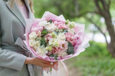 Genç kız güzel bahar buket tutarak. çiçek aranjmanı peonies ile. Renk pembe. Bir çiçekçi dükkanı, küçük bir aile şirketi kavramı