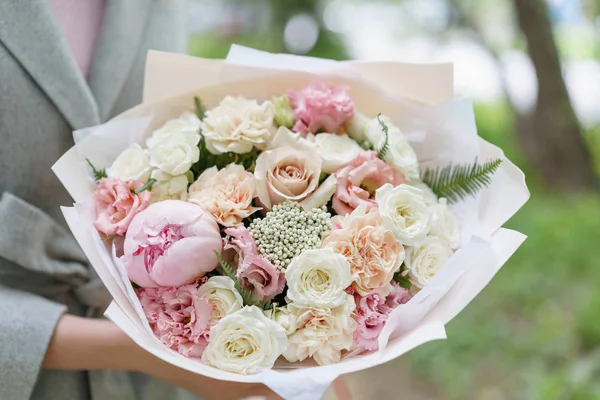 beautiful spring bouquet. flower arrangement with peonies. Color light pink. The concept of a flower shop, a small family business