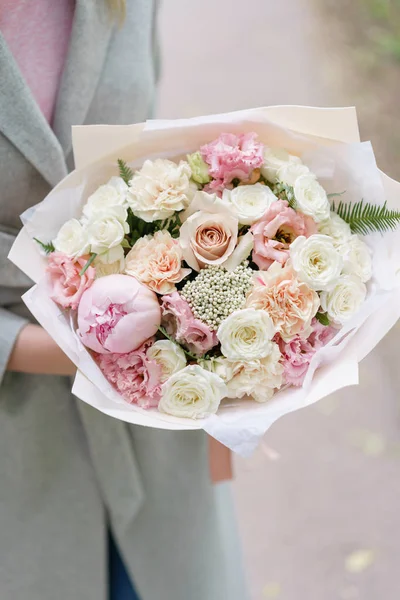 stock image Young girl holding a beautiful spring bouquet. flower arrangement with peonies. Color light pink. The concept of a flower shop, a small family business