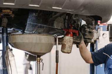 Debriyaj birim motor yağı sızıntı sonra durulayın. Değişim ve onarım debriyaj, sürücü aks. kaldırdı bir araba altında çalışıyor. Profesyonel mekanik iş bakım araba. Garajda araba servisi.
