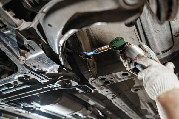 Carro mecânico inspecionando roda do carro e reparar detalhe suspensão. Elevado automóvel na estação de serviço de reparação. substituição de ferrule e alavancagem — Fotografia de Stock