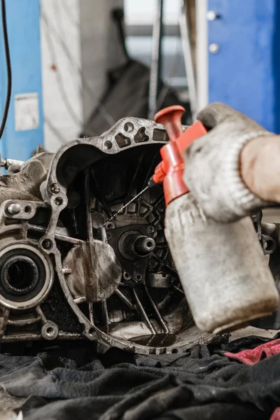 Enxaguar a unidade de embreagem após o vazamento de óleo do motor. Alterar e reparar embreagem, eixo de acionamento. a trabalhar debaixo de um carro levantado. Carro mecânico profissional da manutenção do trabalho. Garagem de serviço de carro . — Fotografia de Stock