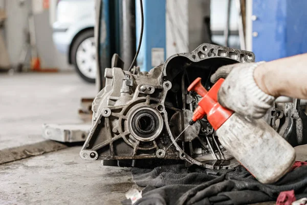 Enjuague la unidad de embrague después de la fuga de aceite del motor. Cambio y reparación de embrague, eje motriz. trabajando debajo de un coche levantado. Trabajo mecánico profesional coche de mantenimiento. Garaje servicio de coches . — Foto de Stock