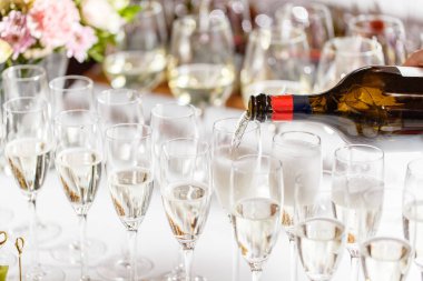 Barmen dökme şampanya veya şarap şarap gözlük Restoran tablo içine. düğün töreni ya da mutlu yeni yıl Ziyafet