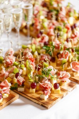 ciddi mutlu yeni yıl ziyafet. Çok fazla bardak şampanya veya şarap Restoran tablo. büfe masa aperatifler dolu. kanepeler, bruschetta ve ahşap plaka tahta üzerinde küçük tatlılar