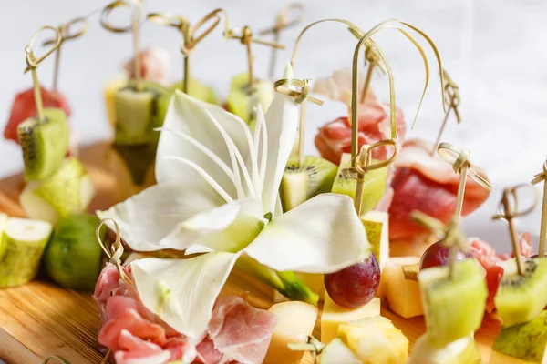 Solemne banquete feliz año nuevo. Un montón de copas de champán o vino en la mesa en el restaurante. mesa buffet con un montón de deliciosos aperitivos. canapés, bruschetta, y pequeños postres en placa de madera — Foto de Stock