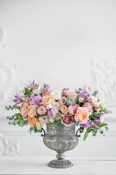 Nádherná kytice různých květin. aranžmá ve vintage Kovová váza. prostřený stůl. Barva Fialová a broskvová — Stock fotografie