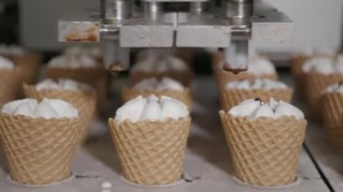 Robot makine otomatik olarak dondurma ve çikolata gofret bardak içki alıyor. Konveyör otomatik satırları dondurma külah imalatı için. Gofret bardak ve koniler. Büyük sanayi üretim.