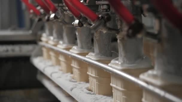 Μηχάνημα ρομπότ αυτόματα χύνει παγωτά σε ένα Κύπελλα γκοφρέτα. Η μεταφορική Αυτόματες γραμμές για την παραγωγή χωνάκια παγωτού. Κύπελλα γκοφρέτα και κώνοι. Μεγάλες βιομηχανικής παραγωγής. — Αρχείο Βίντεο