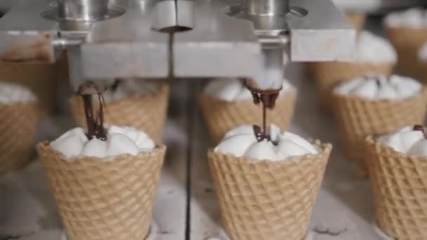 Robotermaschine gießt automatisch Eis und Schokolade in einen Waffelbecher. die automatischen Förderanlagen für die Herstellung von Eistüten. Hostientassen und Zapfen. große industrielle Produktion. — Stockvideo