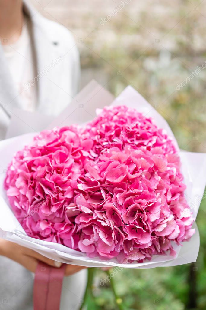 pink hydrangea. Young girl holding a flower arrangement. Beautiful summer bouquet. The concept of a flower shop. Content for the catalog