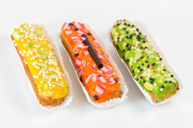 Tatlı ve renkli eklerleri. Grup Fransız tatlı pasta beyaz arka plan üzerinde. Kremalı pasta tatlı içinde krem şanti ile