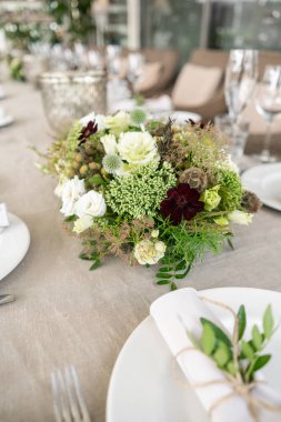 Düğün ya da gala yemeği. Sandalye ve masa için konuklar, çatal bıçak takımı ve çanak çömlek ile servis edilir. Keten masa örtüsü runner ile kaplı. terasta parti