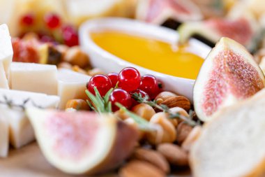 Işık İtalyan aperatifleri. Akşam yemeği açık büfe masada. Peynir tabağı. Lezzetli peynir karışımı ahşap masa üzerinde. Ahşap bir tabakta yemek tatma. Yiyecek şarap.