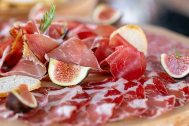 Işık İtalyan aperatifleri. Akşam yemeği açık büfe masada. Yemek tepsisi ile lezzetli salam, adet dilimlenmiş jambon, sosis. Kesme sosis ve kutlama bir tabloda tedavi et.