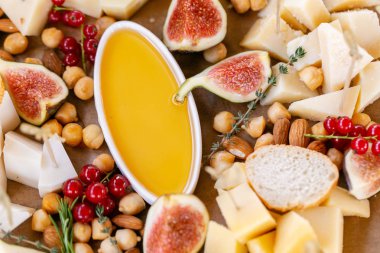 Işık İtalyan aperatifleri. Akşam yemeği açık büfe masada. Peynir tabağı. Lezzetli peynir karışımı ahşap masa üzerinde. Ahşap bir tabakta yemek tatma. Yiyecek şarap.