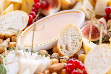 Işık İtalyan aperatifleri. Akşam yemeği açık büfe masada. Peynir tabağı. Lezzetli peynir karışımı ahşap masa üzerinde. Ahşap bir tabakta yemek tatma. Yiyecek şarap.