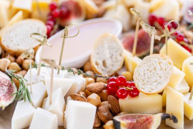 Peynir tabağı. Lezzetli peynir karışımı baget kruton, frenk üzümü, tatlı incir, badem, bal ahşap masa üzerinde. Ahşap bir tabakta yemek tatma. Yiyecek şarap.