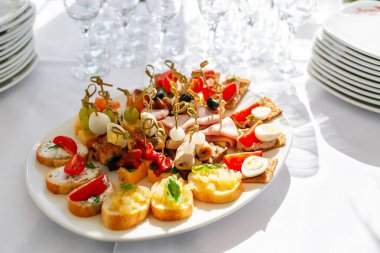 ağırbaşlı ziyafet. Çok fazla bardak şampanya veya şarap Restoran tablo. büfe masa aperatifler dolu. kanepeler, bruschetta ve ahşap plaka tahta üzerinde küçük tatlılar