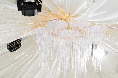 Kristal avize yakın çekim. Bir düğün için bir çadır altında güzel ziyafet salonu. İç bir düğün çadırı dekorasyon misafirler için hazır.