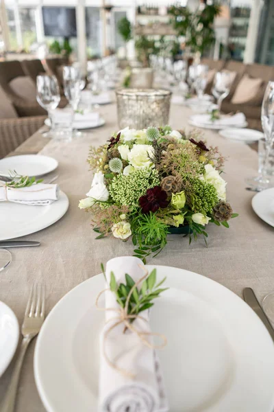 Wedding Banquet or gala dinner. The chairs and table for guests, served with cutlery and crockery. Covered with a linen tablecloth runner. party on terrace