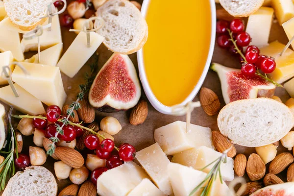 Işık İtalyan aperatifleri. Akşam yemeği açık büfe masada. Peynir tabağı. Lezzetli peynir karışımı ahşap masa üzerinde. Ahşap bir tabakta yemek tatma. Yiyecek şarap.