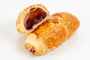 Lezzetli puf böreği tatlısı yarıya. Meyve ile lezzetli hamur işleri üzerinde açık renkli reçel. Berry, çilek veya ahududu