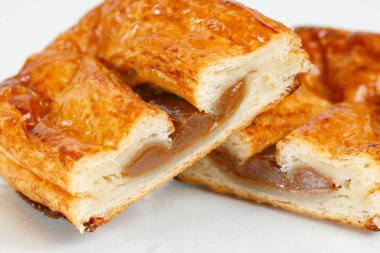 Lezzetli puf böreği tatlısı yarıya. Meyve ile lezzetli hamur işleri üzerinde açık renkli reçel. yoğunlaştırılmış süt