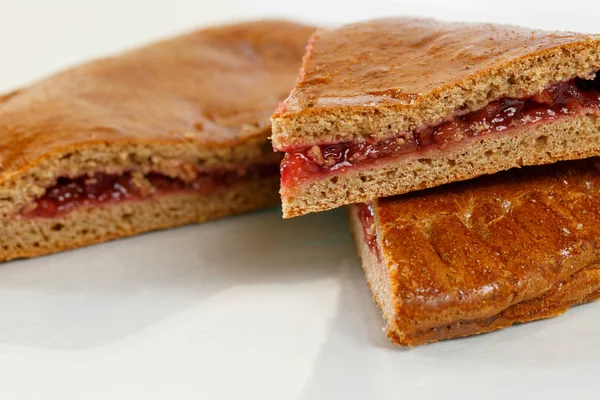 Lekker gebak of rogge deeg in tweeën gesneden. Heerlijke gebakjes met fruit jam op lichte achtergrond. bessen, aardbeien of frambozen — Stockfoto