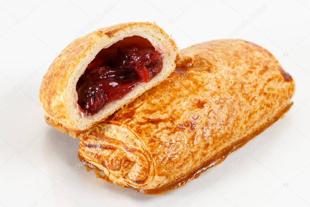 Tasty puff pastry dessert cut in half . Delicious pastries with fruit jam on light background. berry, strawberries or cherry