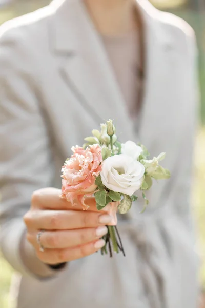 Boutonniere입니다. 젊은 여자는 아름 다운 봄 꽃을 들고. lisianthus와 꽃 배열입니다. 컬러 라이트 핑크입니다. 밝은 새벽 또는 일몰 태양 — 스톡 사진