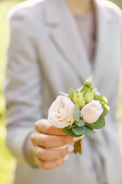 Boutonniere입니다. 젊은 여자는 아름 다운 봄 꽃을 들고. 장미와 꽃 배열입니다. 컬러 라이트 핑크입니다. 밝은 새벽 또는 일몰 태양 — 스톡 사진