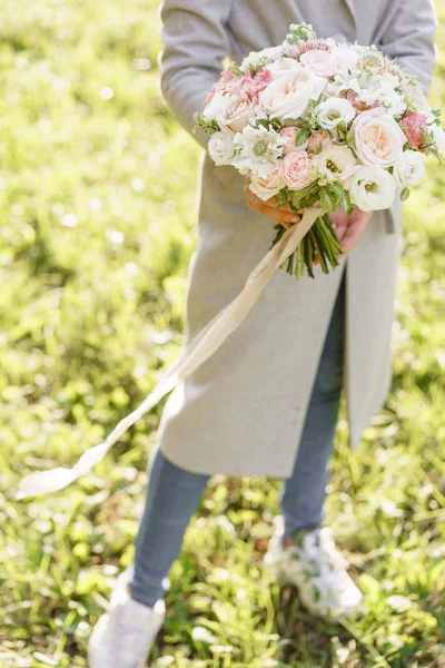 Молода дівчина тримає гарний весняний букет. квіткова композиція з садовими трояндами. Колір світло-рожевий. Яскравий світанок або захід сонця — стокове фото