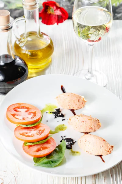 Салат капрезе с моцареллой, помидорами, базиликом и бальзамическим уксусом на белой тарелке — стоковое фото