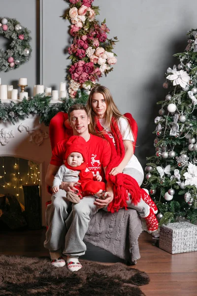 Sevgi dolu aile mutlu Noeller ve mutlu yeni yıl. Neşeli güzel insanlar. Anne, baba ve küçük bebek evlat. Anne ve çocuk Noel ağacı ve beyaz şömine yakın kapalı eğleniyor. — Stok fotoğraf