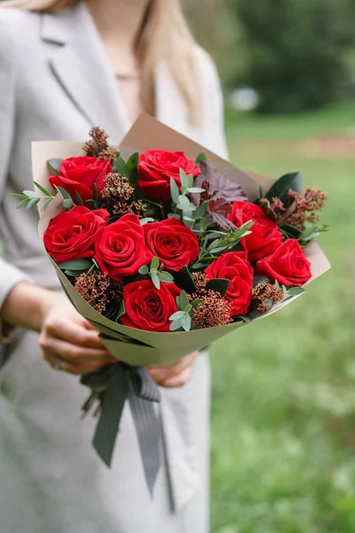 Mulher encantadora segurando um lindo buquê de outono. arranjo de flores com cravos e rosas vermelhas jardim. Cor rosa. gramado verde no fundo — Fotografia de Stock