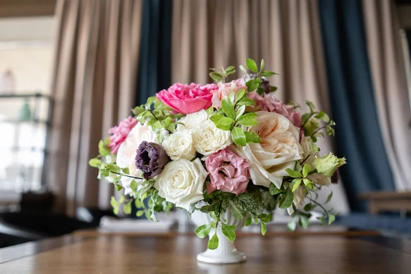 Arrangement de fleurs fraîches dans des couleurs pastel avec un accent lumineux. Fond de mariage. table dans un restaurant. différentes variétés de roses de jardin et d'arbustes dans un vase léger sur une table en bois — Photo