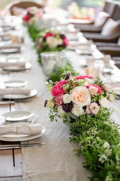 Wedding Banquet or gala dinner. The chairs and table for guests, served with cutlery and crockery. Covered with a linen tablecloth runner. party on terrace